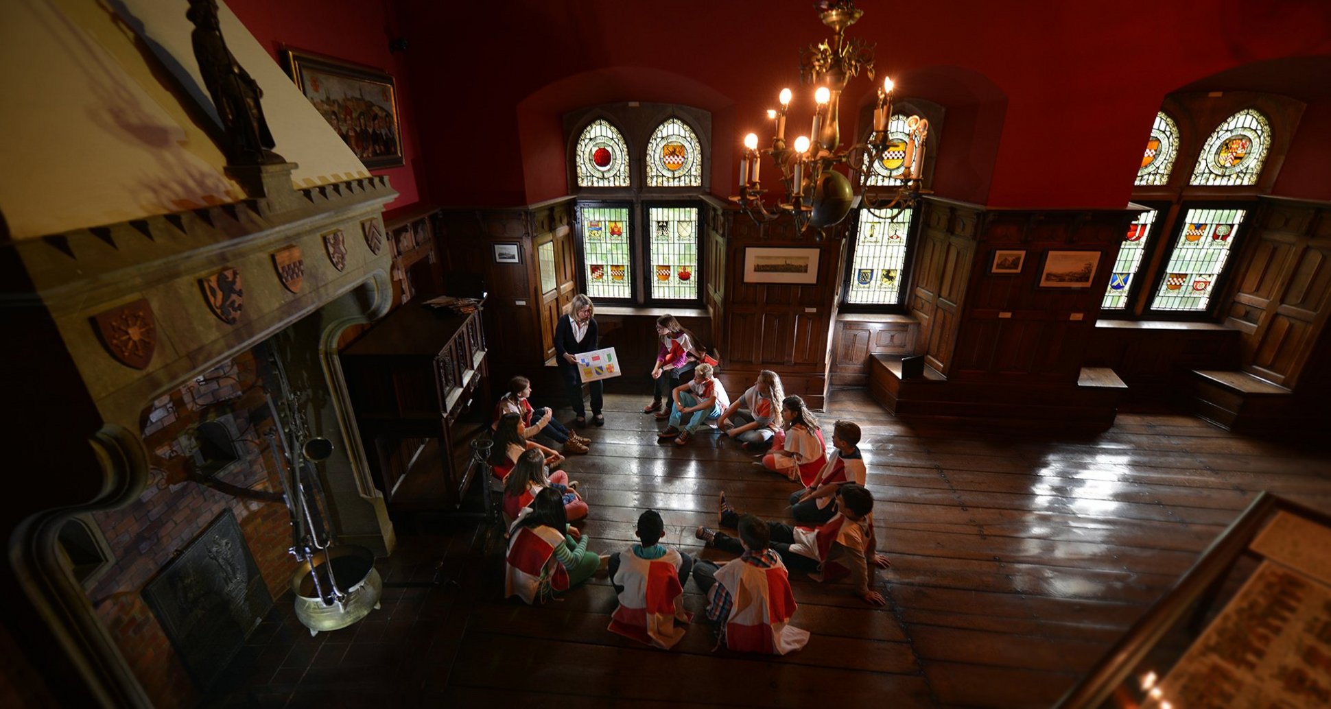 Kinder sitzen im Museum der Burg Altena und absolvieren ihre Ritterprüfung