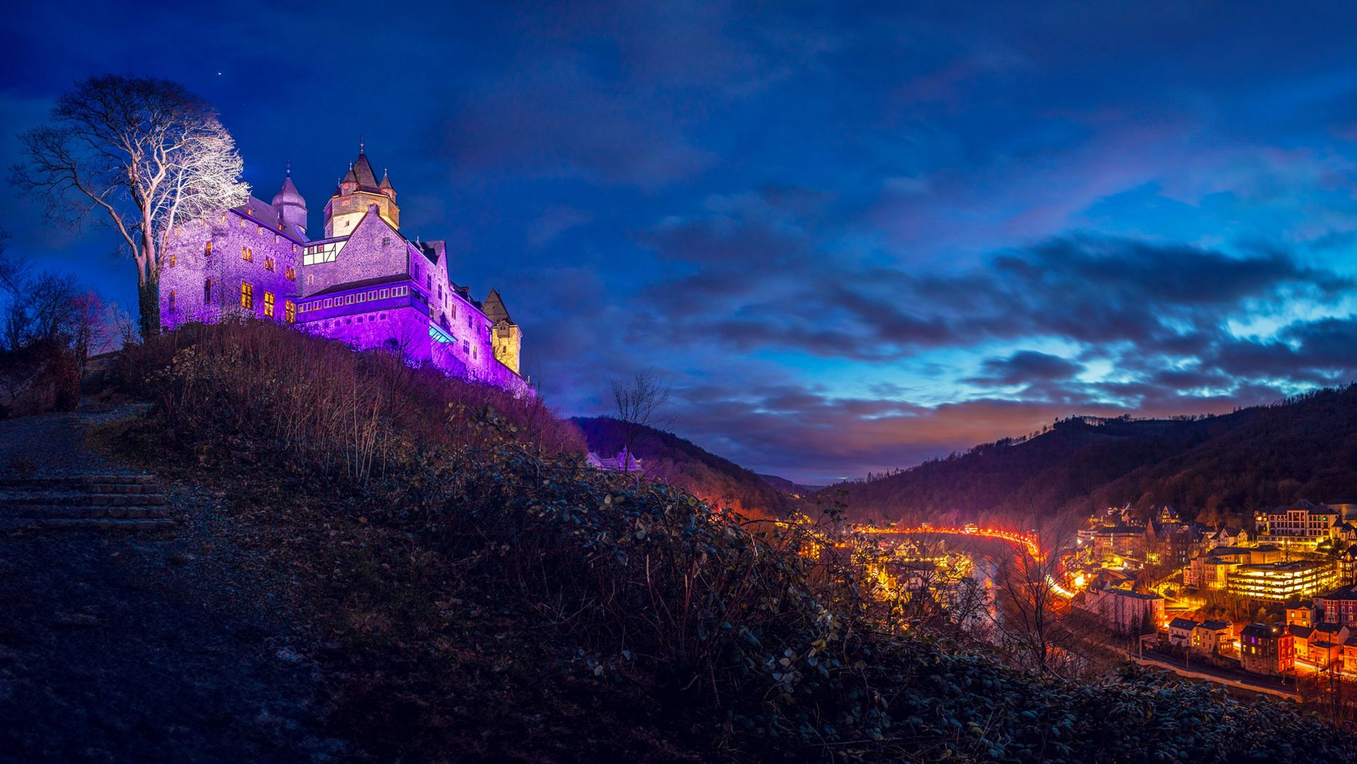 Burg Altena leuchtet in bunten Farben beim Glanzlicht 2023 über der Stadt Altena