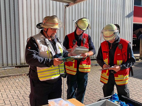 Großübung der Feuerwehr, drei Sanitäter besprechen sich