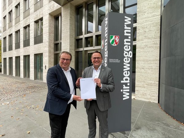 Der nordrhein-westfälische Verkehrsminister Oliver Krischer (links) hat dem Landrat des Märkischen Kreises, Marco Voge, einen Förderbescheid über 2,96 Millionen Euro für das ÖPNV-Angebot überreicht. Foto: Ministerium für Umwelt, Naturschutz und Verkehr des Landes Nordrhein-Westfalen 